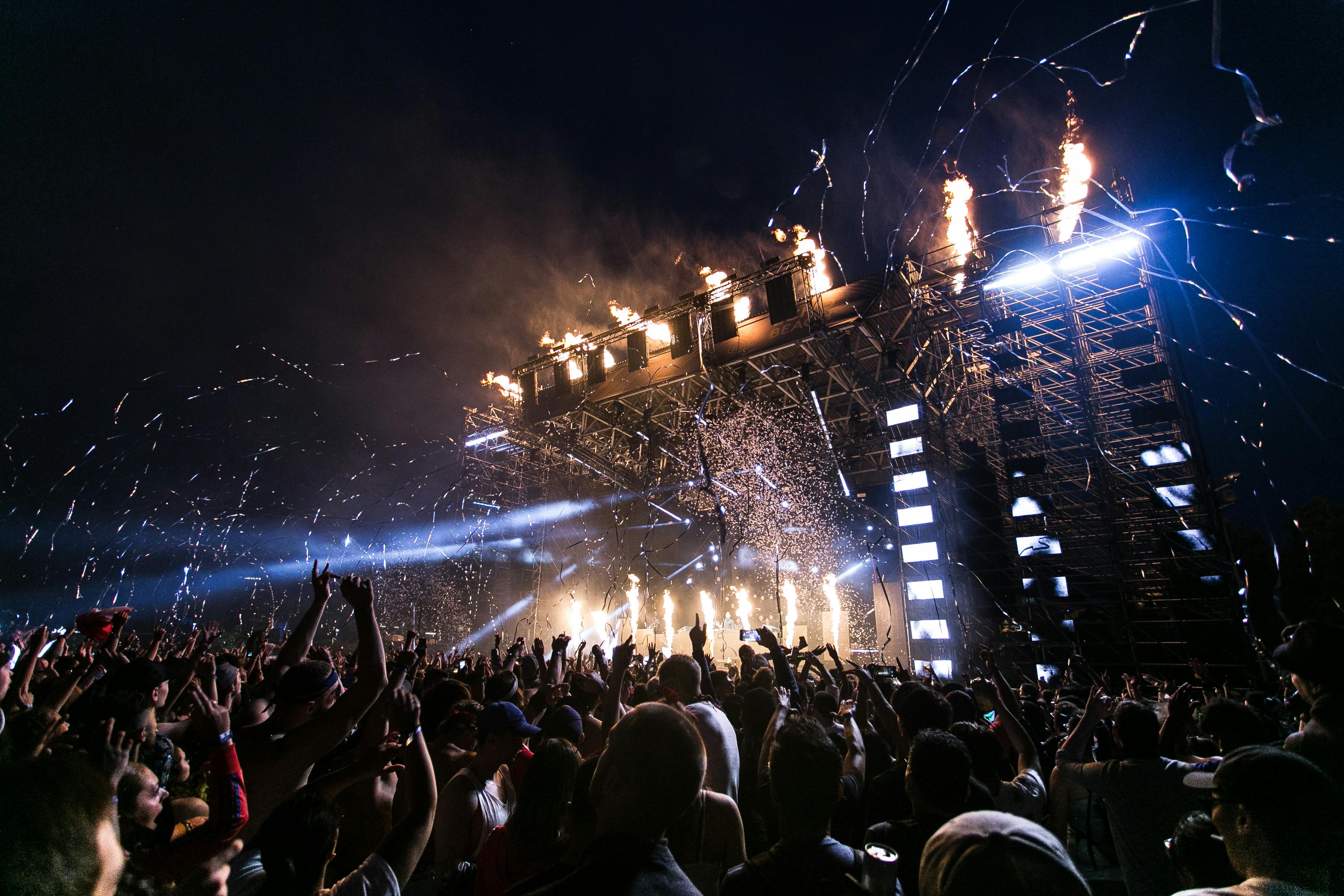 DJ performing live on stage with crowd and lights